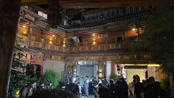 Un edificio tradicional de varios pisos con balcones de madera y un patio central.