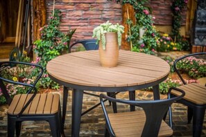 A round wooden table with a woven vase and two chairs. - Sansheng Garden Inn (Puzhehei Xianrendong Shop) (Qiubei)