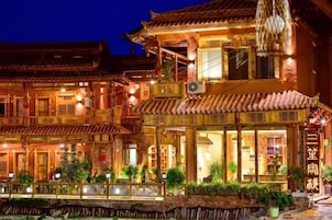 A traditional building with multiple levels, large windows, and a balcony.