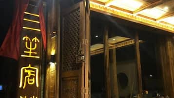 Una entrada con puerta de madera y letrero con luces.