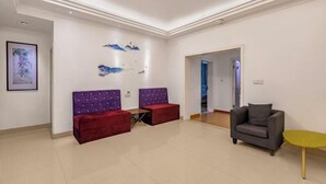 A spacious room with a red sofa, a grey armchair, and a small yellow table. - Hanxiangju Homestay (Wuzhen Xizha Scenic Spot) (Tongxiang)