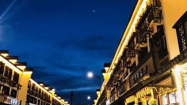 A nighttime view of a street lined with buildings with illuminated balconies and signs. - Hanxiangju Homestay (Wuzhen Xizha Scenic Spot) (Tongxiang)