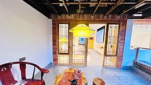 A room with a wooden table, a red chair, and a large window with a view.