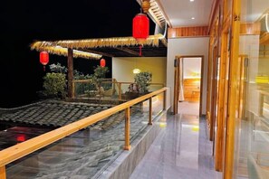 A hotel interior with a traditional thatched roof structure, a glass railing, and a modern interior design. - kong shan niao yumin su (Ya'an)