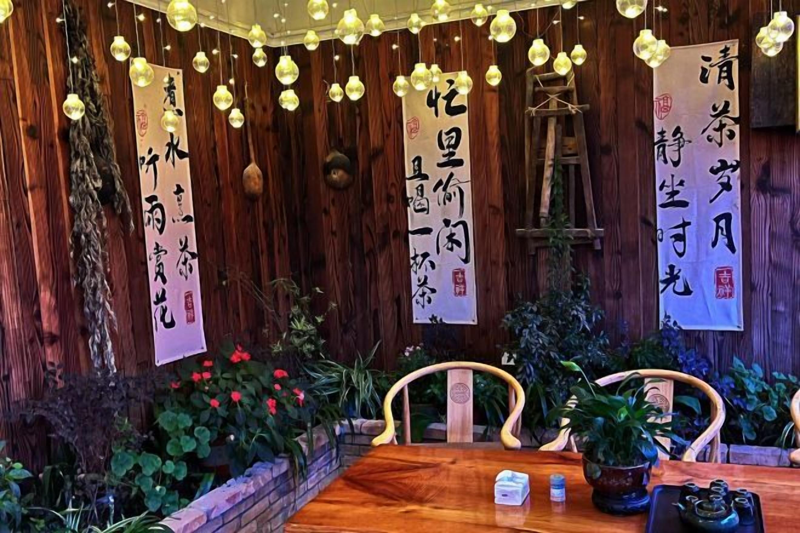 A wooden interior with a table, chairs, and hanging decorations.