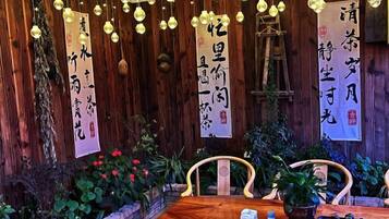 A wooden interior with a table, chairs, and hanging decorations.