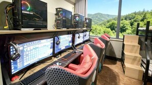 A room with multiple computer monitors, a keyboard, and a chair.