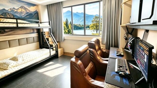 A room with bunk beds, a desk with a computer, and a view of mountains through the window.