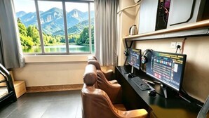 A room with a desk, computer, and massage chairs.