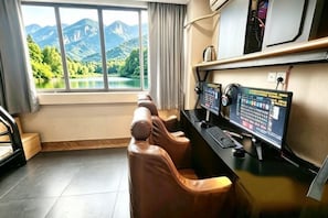 A room with a desk, computer, and massage chairs.