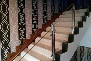 Een trap met een houten leuning en glazen balustrades.