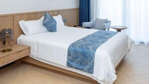 A hotel room with a bed, bedside table, chair, and a small round table. - Yangzi Hotel (Nanjing)