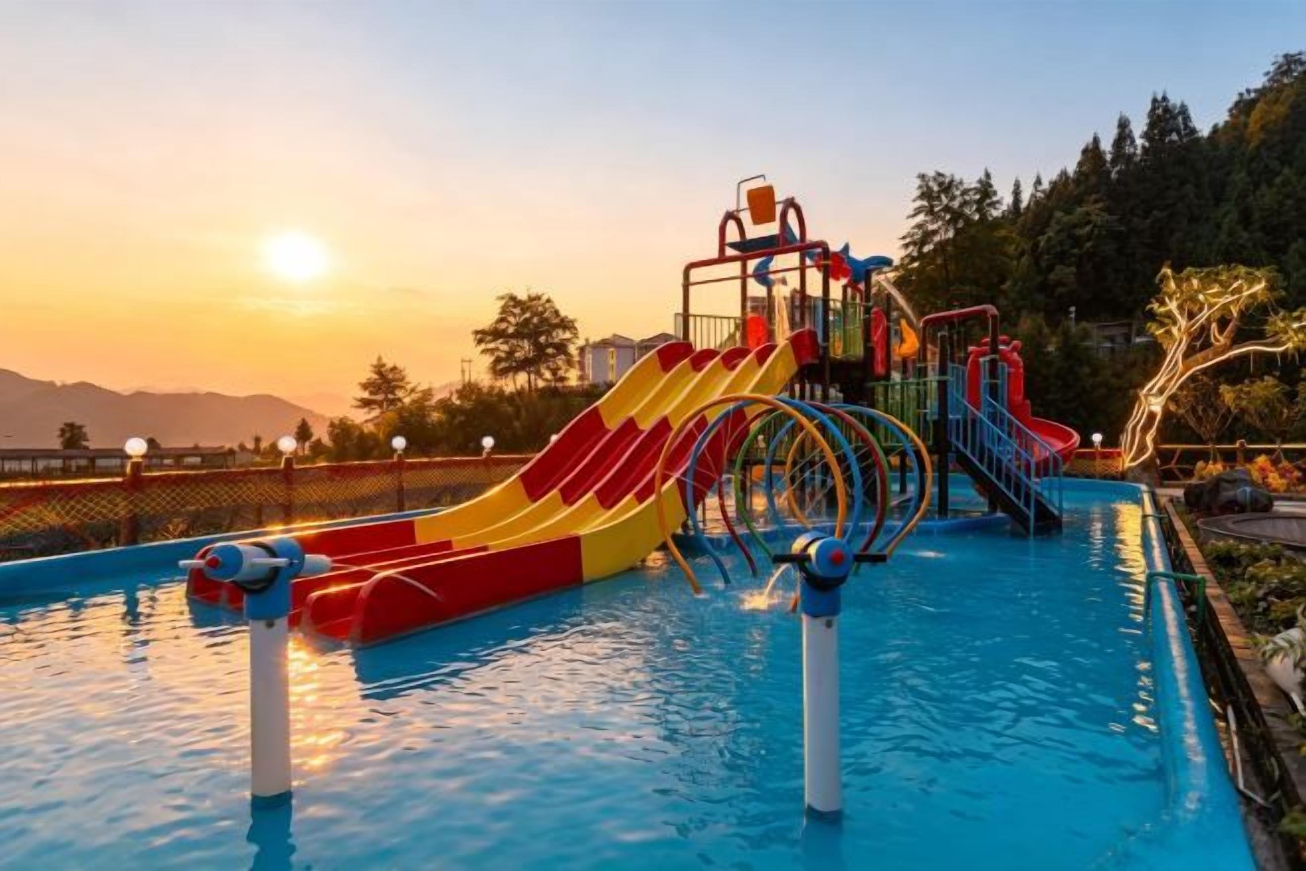 A swimming pool with slides and a water play area.