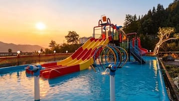 A swimming pool with slides and a water play area.