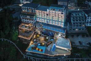Un hotel de varios pisos con un patio central, varios balcones y una piscina.