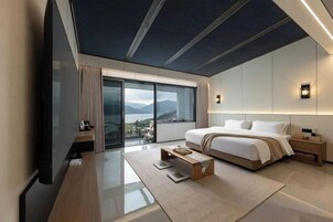 Habitación de hotel moderna con una cama grande, un escritorio y vistas al exterior.