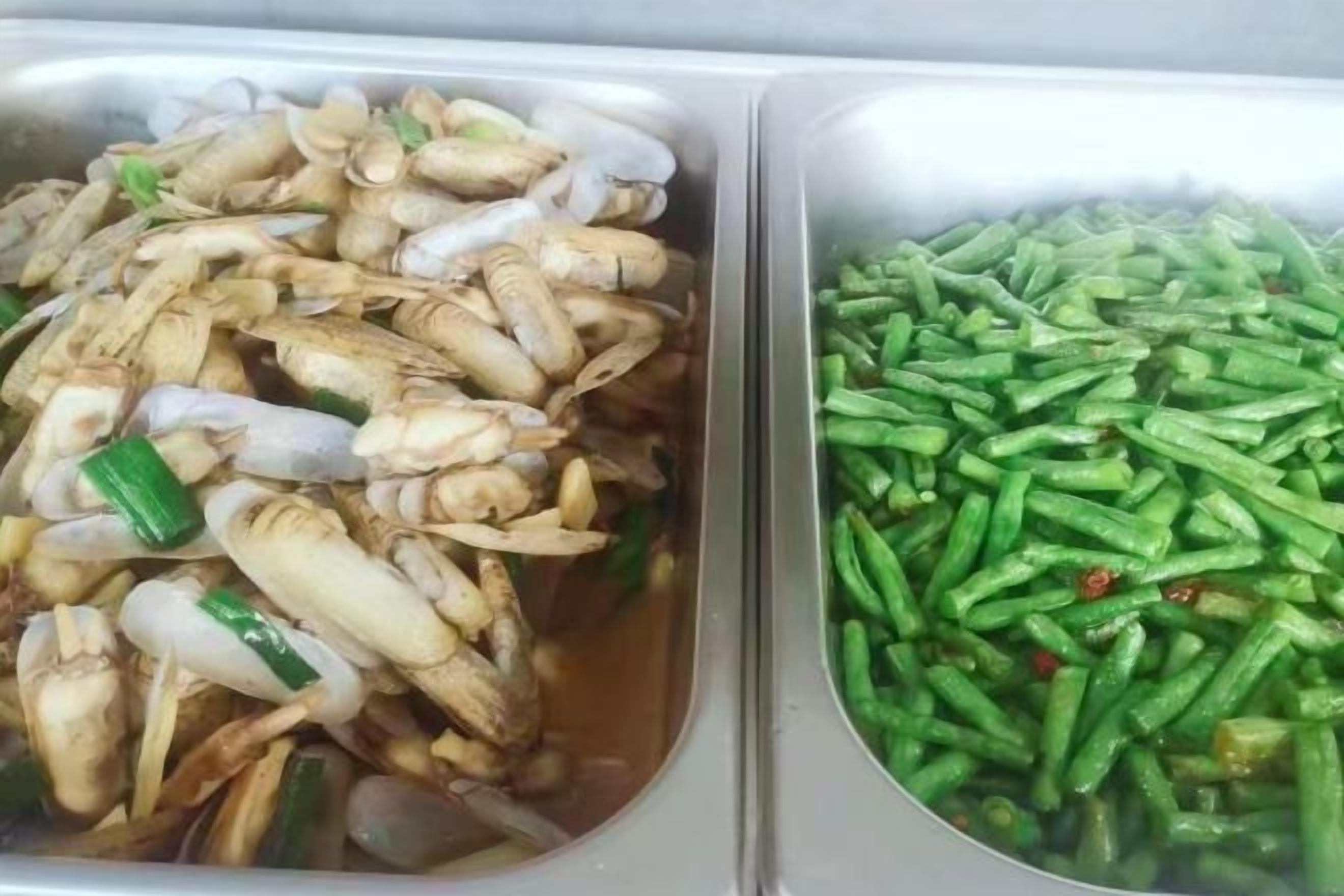 Two containers with food items, one with what appears to be seafood and the other with green vegetables.
