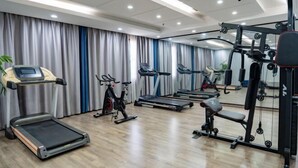 A gym with treadmills, elliptical machines, and weightlifting equipment. - Kunxing Century Hotel (Lotus Plaza) (Lianhua)