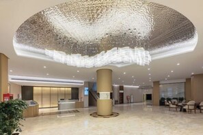A spacious lobby with a large, circular ceiling feature, a reception desk, and seating area. - Kunxing Century Hotel (Lotus Plaza) (Lianhua)