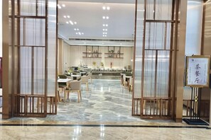 A hotel lobby with a reception desk, seating area, and a decorative wall with calligraphy. - Kunxing Century Hotel (Lotus Plaza) (Lianhua)