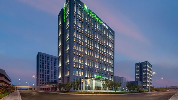A multi-story hotel with a prominent 'Holiday Inn Express' sign, large windows, and a modern architectural design. - Holiday Inn Express Rongcheng Science And Technolo (Weihai)