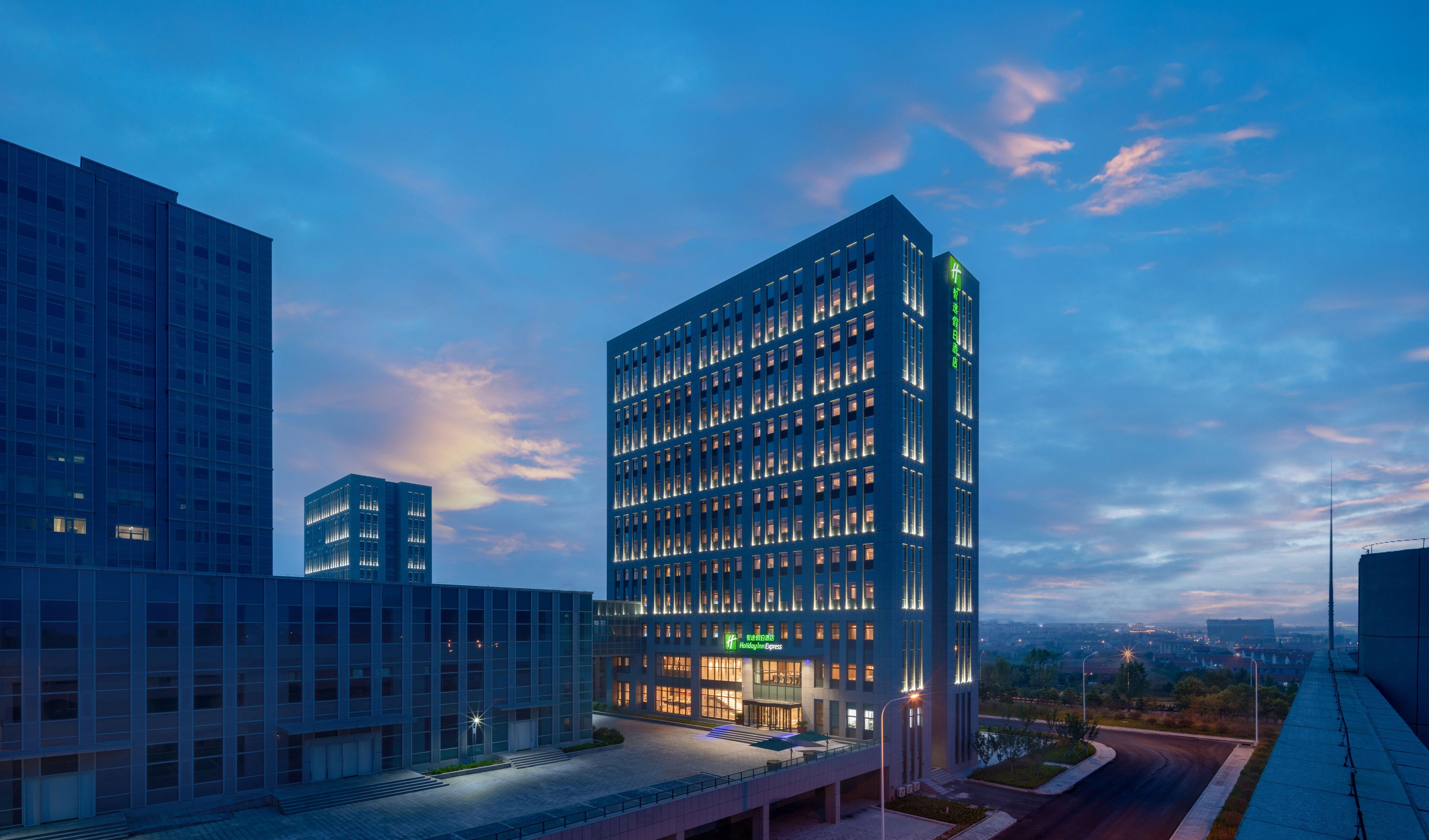 Een modern hotelgebouw met een glazen gevel, meerdere verdiepingen en een opvallende entree.
