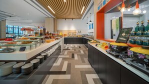 Zona de bufé con diversas opciones de comida, un mostrador con menú digital y piso estampado.