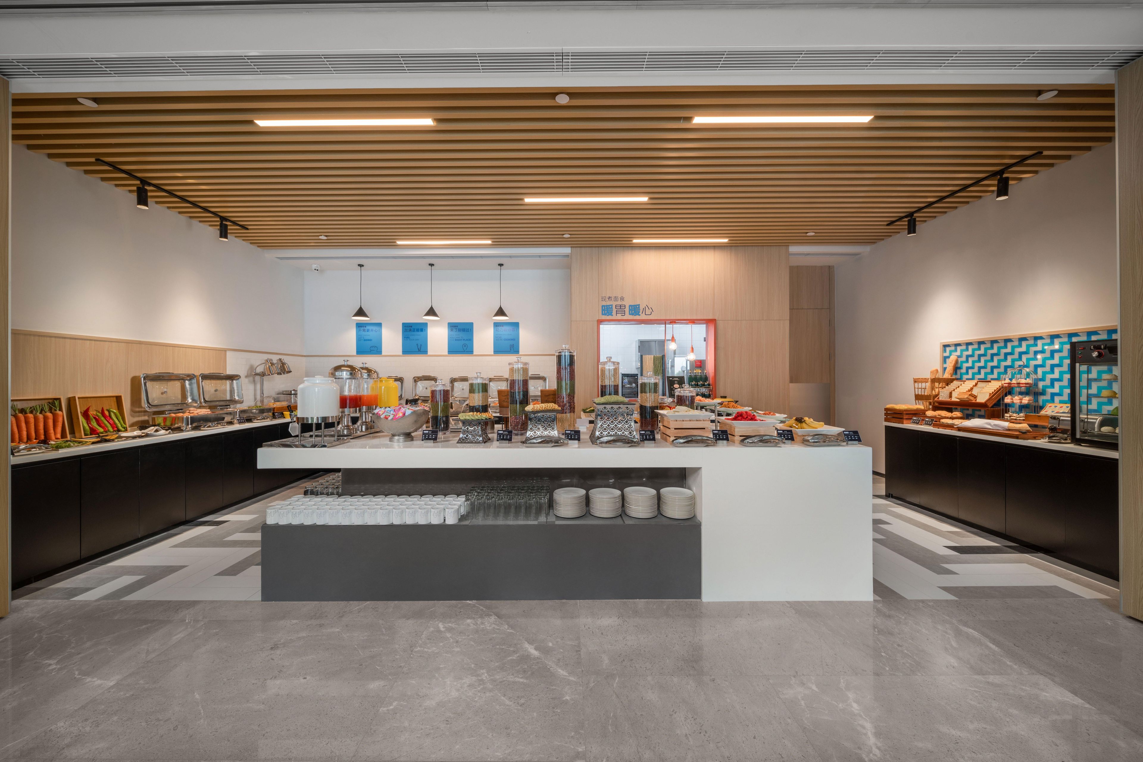 Una moderna disposición de bufé con una zona de servicio central, varias estaciones de comida y un diseño limpio y contemporáneo.