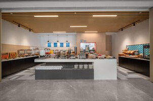Una moderna disposición de bufé con una zona de servicio central, varias estaciones de comida y un diseño limpio y contemporáneo.