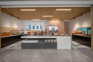 Una moderna disposición de bufé con una zona de servicio central, varias estaciones de comida y un diseño limpio y contemporáneo.