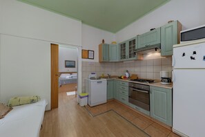 A compact kitchen with a microwave, stove, and sink. There is a small refrigerator and a wooden floor. - Oasis Of Peace In Lopar, Lopar, Croatia (Lopar)