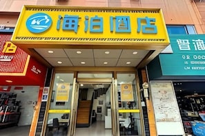A hotel entrance with a yellow sign, glass doors, and a staircase leading inside. - Hi Inn (Shanghai Jinshan Zhujing Jinlong New Street) (Shanghai)