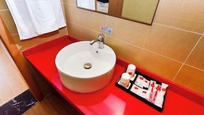 A bathroom with a white sink, red countertop, and a mirror above the sink. There is a towel rack with a white towel hanging on it. - Shankee Hotel (Qingdao Development Zone Xiangjiang Second Road) (Qingdao)