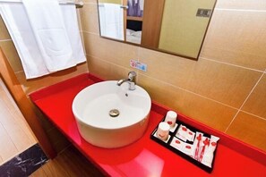A bathroom with a white sink, red countertop, and a mirror above the sink. There is a towel rack with a white towel hanging on it. - Shankee Hotel (Qingdao Development Zone Xiangjiang Second Road) (Qingdao)