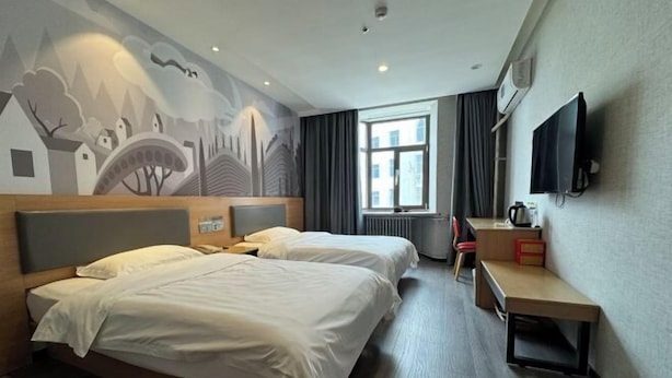 A hotel room with two beds, a desk, a chair, a TV, and a mural on the wall. - Shankee Hotel (Qingdao Development Zone Xiangjiang Second Road) (Qingdao)