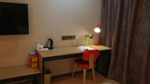 A small, neatly arranged room with a desk, chair, and a flat-screen TV mounted on the wall. - Shankee Hotel (Qingdao Development Zone Xiangjiang Second Road) (Qingdao)
