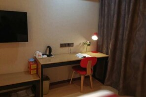 A small, neatly arranged room with a desk, chair, and a flat-screen TV mounted on the wall. - Shankee Hotel (Qingdao Development Zone Xiangjiang Second Road) (Qingdao)