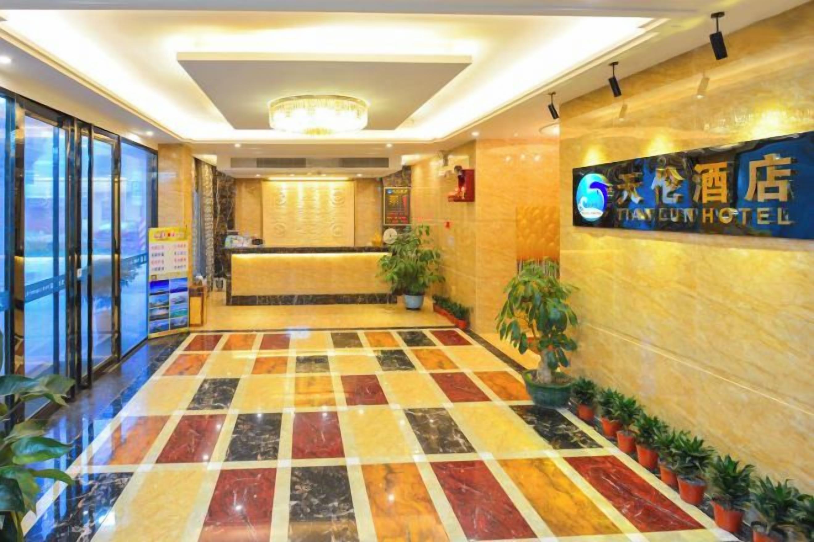 A hotel reception area with a check-in counter, a reception desk, and a tiled floor.