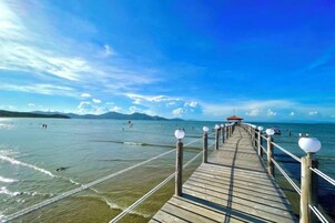 Un muelle de madera que se adentra en una masa de agua bajo un cielo despejado.
