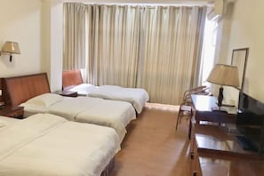 A hotel room with two beds, a desk, a chair, a television, and a window with curtains. - Riyuehe Hostel (Beihai)
