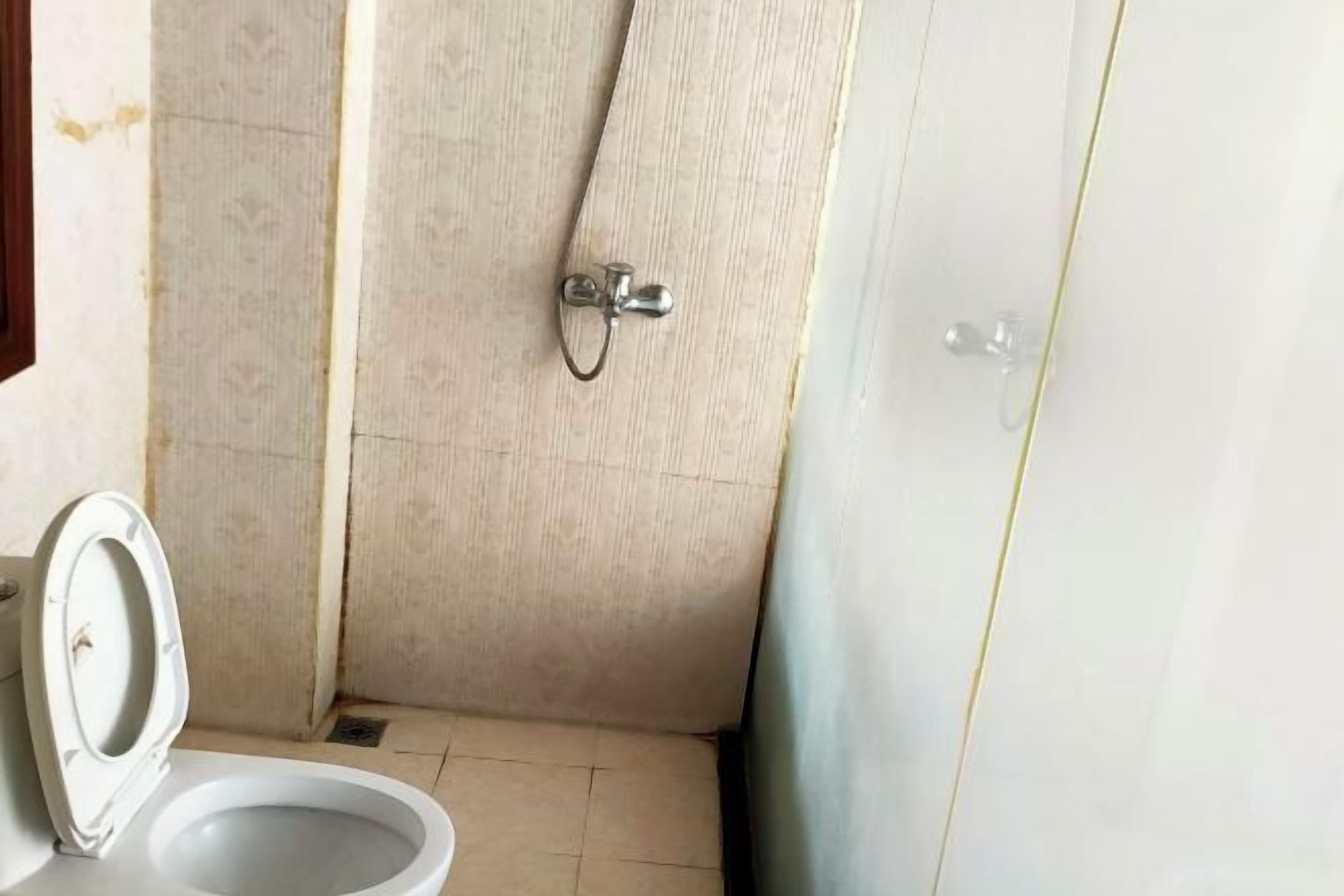 A small bathroom with a toilet, a shower, and a sink.