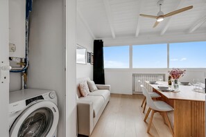 A modern kitchen with a dining area, a washing machine, and a large window providing a view. - Sky View Apartment Monopoli, Monopoli, Italy (Monopoli)