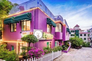 A purple building with a sign that reads 'SUMMER' and a clock. - Summer Tree Inn (Sanya)