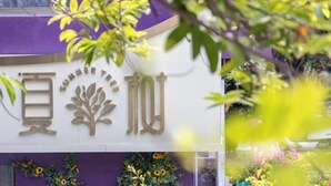 A storefront with a sign that reads "Summer Tree" and displays various flowers and plants. - Summer Tree Inn (Sanya)