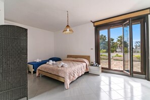 A modern bedroom with a bed, a bedside table, a hanging light fixture, and a sliding glass door leading to an outdoor area. - Salento Sweet Home Sea View with Garden, Lecce, Italy (Lecce)