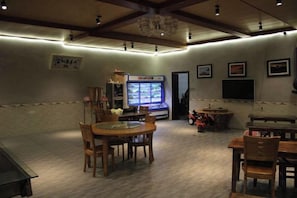 Una habitación con una mesa de comedor, sillas, un televisor y un expendedor.