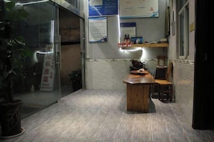 A room with a wooden table and chairs, a potted plant, and a glass door.