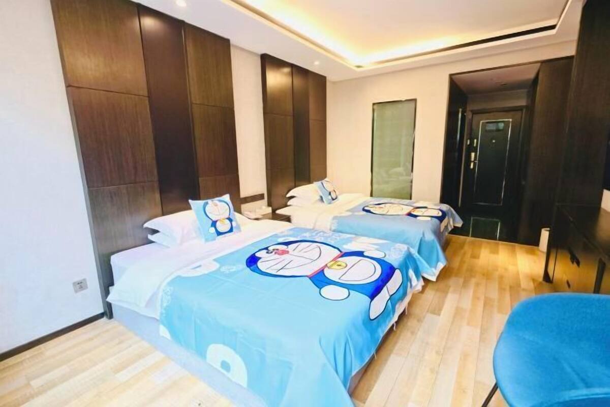 A hotel room with two beds, a wooden floor, and a modern design.