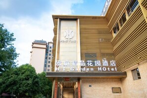 A hotel with a modern facade, a prominent logo, and a sign indicating it's the H. T. Garden Hotel. - Hongting Garden Hotel (Kunming)