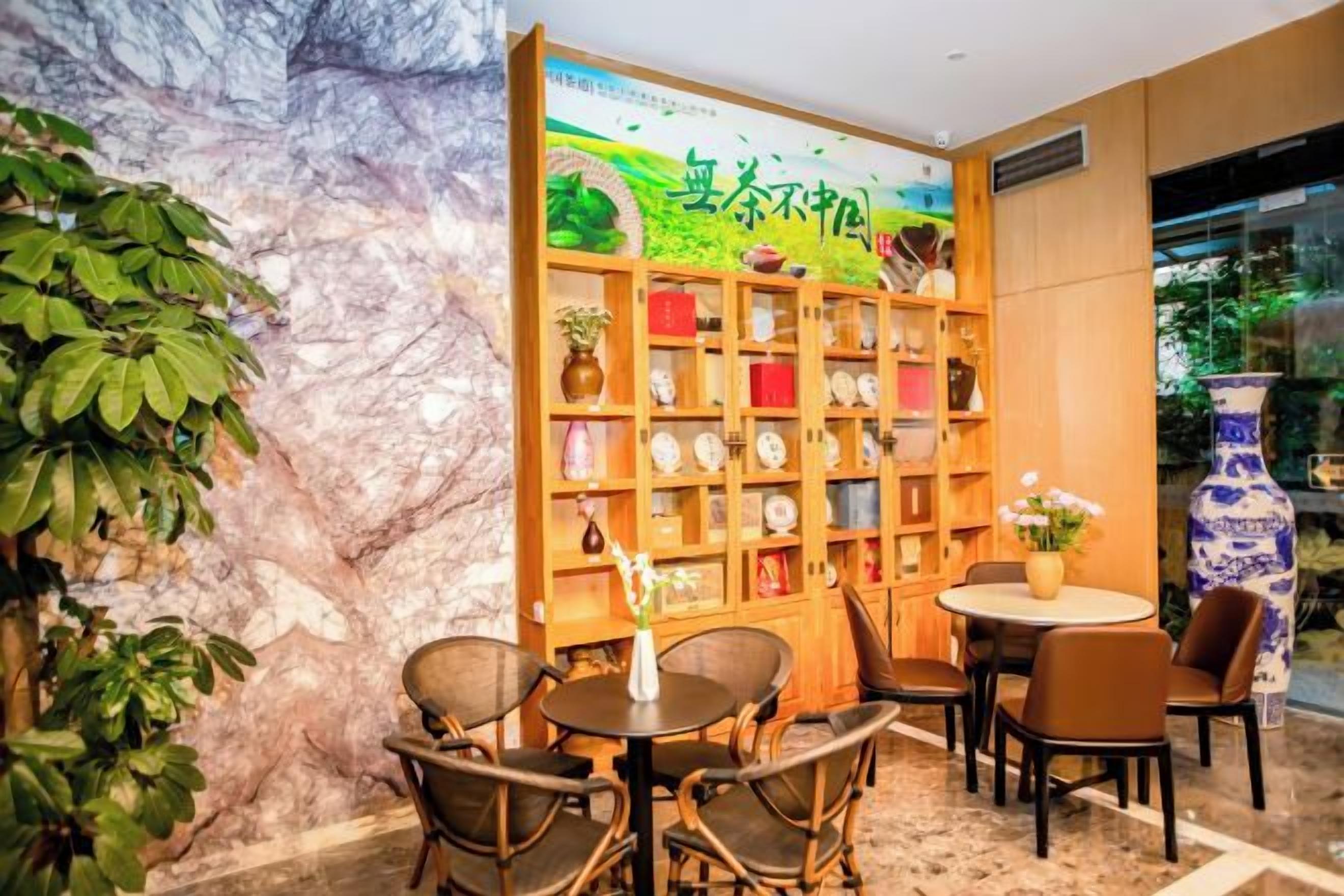 A room with a bookshelf, a round table, and chairs.
